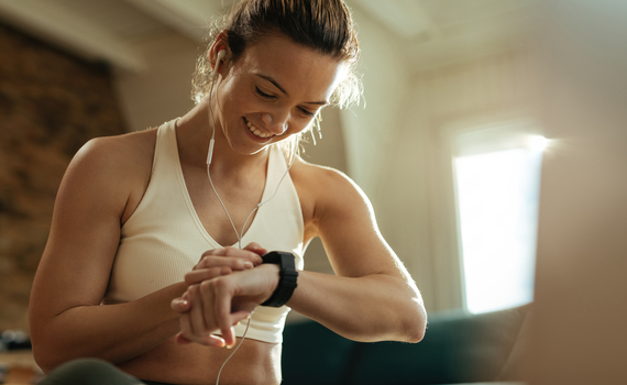 young-happy-sportswoman-checking-heart-rate-on-smart-watch-after-the-workout-