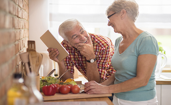 Um homem e uma mulher mais velhos cozinham alimentos saudáveis para um estilo de vida saudável na velhice. 