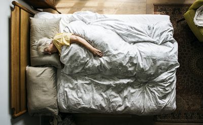 Uma mulher idosa dorme tranquilamente na sua cama com uma temperatura nocturna ideal. 