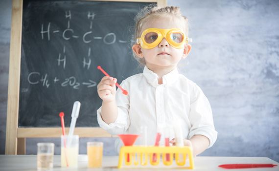Uma rapariga a fingir ser uma cientista numa sala de aula