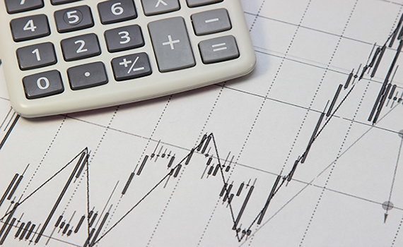Uma calculadora em uma folha de papel mostrando um índice do mercado de ações. 