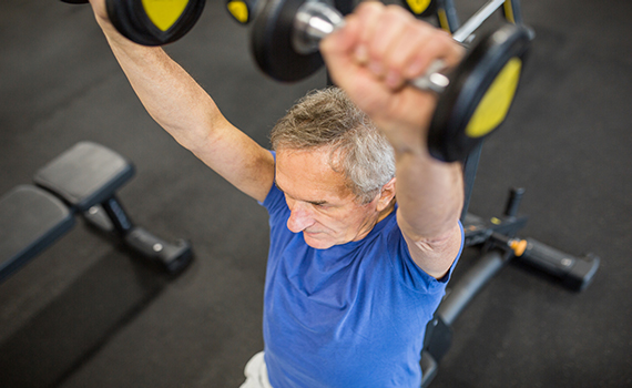 Um adulto mais velho a fazer treino de força para melhorar a sua saúde muscular e física.