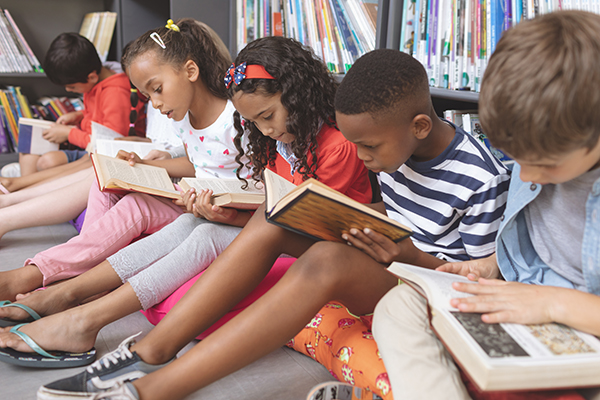 Um grupo de crianças a ler numa biblioteca escolar. 