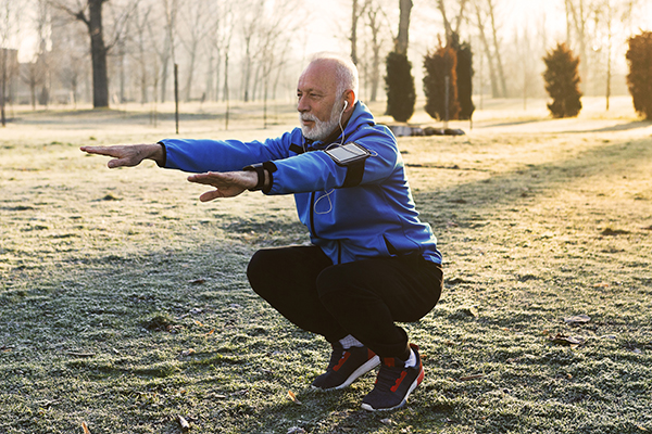 Um adulto mais velho a fazer exercício sem supervisão num parque. 