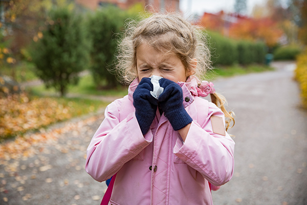 Uma menina constipada a assoar o nariz.  A má qualidade do ar afectou as suas vias respiratórias. 