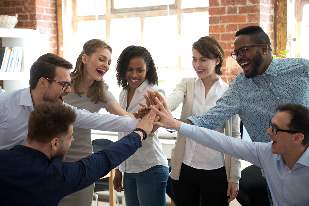 "Colegas felizes e diversificados dão high five juntos para celebrar o excelente trabalho em equipe."
