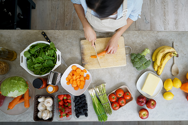 Uma mulher está a cozinhar uma receita vegetariana para prevenir as doenças cardiovasculares e o risco de cancro. 