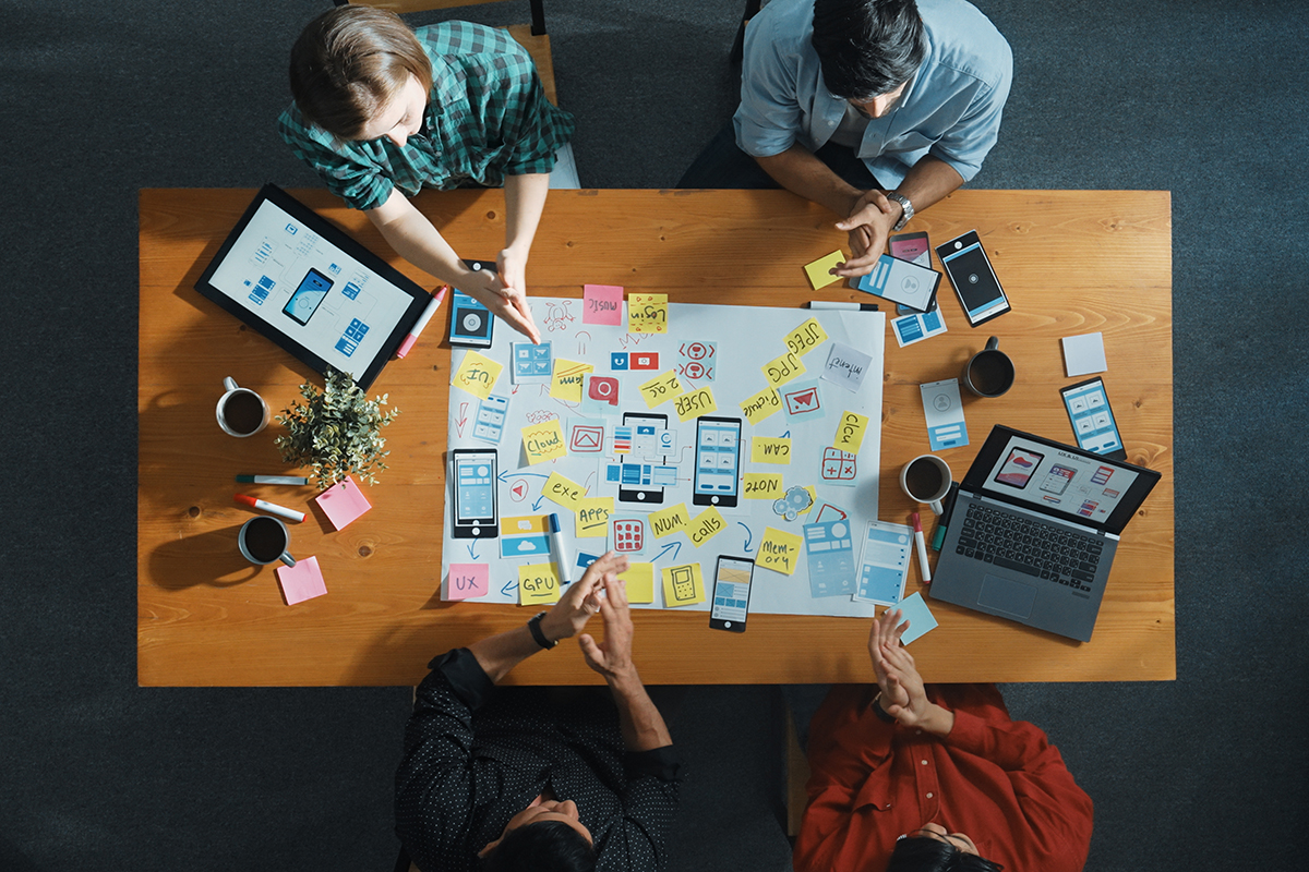 Vista superior de um grupo de empresários trabalhando juntos em um brainstorming ou planejamento de um aplicativo de interface de telefone celular. 