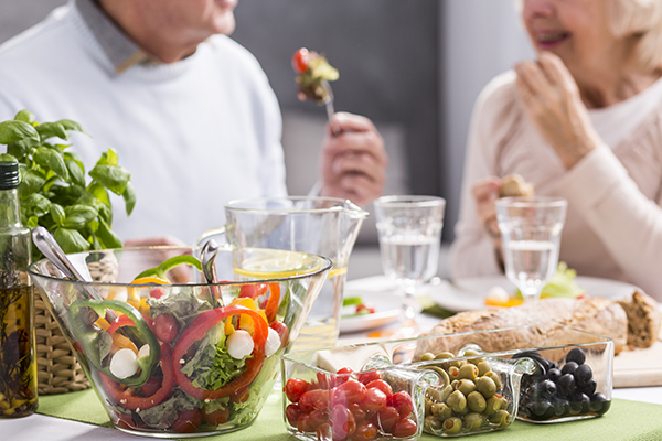  Dois adultos mais velhos a consumir fruta e legumes.