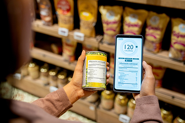 Uma mulher verifica o rótulo de calorias de um alimento enlatado num supermercado.