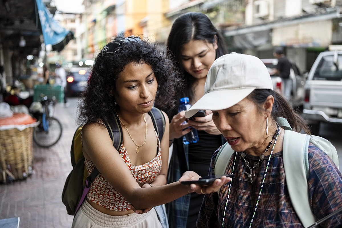 Uma turista segura o telefone para o guia turístico traduzir para ela durante um passeio pela cidade.