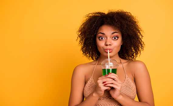 omg-so-delicious-funny-cute-attractive-careless-mixed-race-woman-is-drinking-green-alcohol-cocktail-is-a-plastic-cup-using-a-straw-isolated-on-bright-vivid-background-copy-space