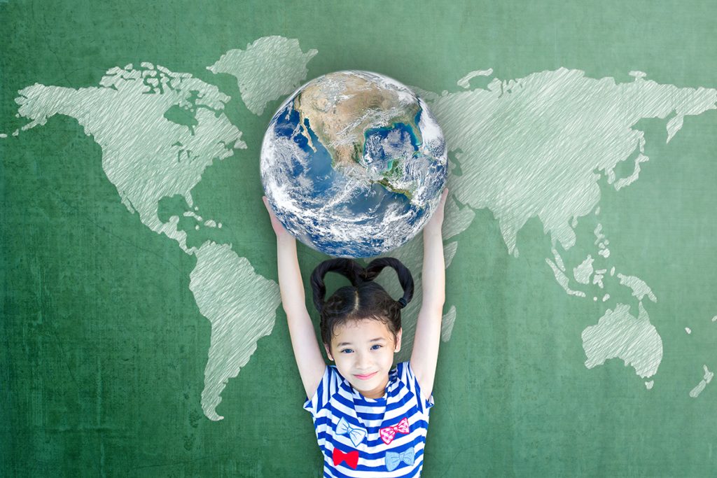 Niña asiática alumna feliz levantando el globo en la pizarra de la escuela por la alfabetización mundo y la igualdad de género concepto elementos de esta imagen amueblada por NASA.