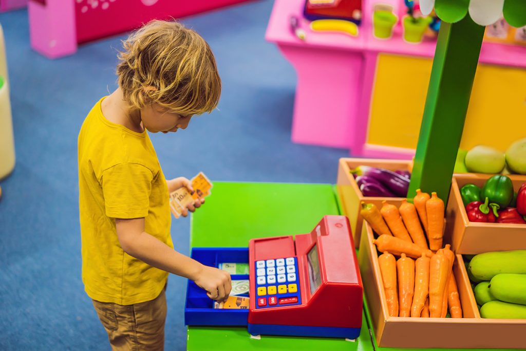 Un niño juega con una máquina registradora. 