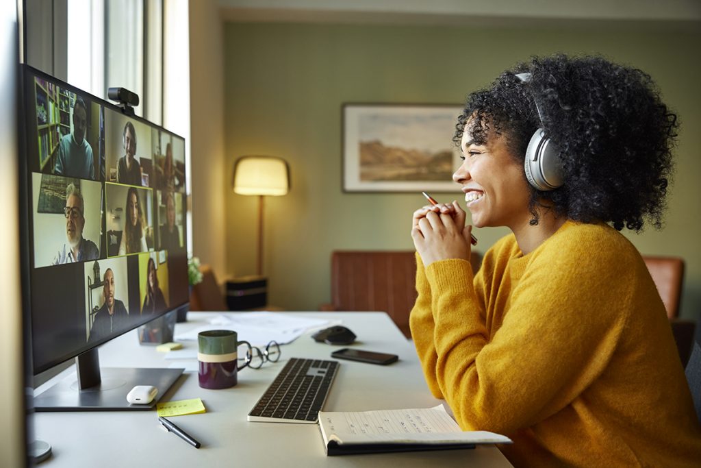 Mujer de negocios con auriculares sonriendo durante una videoconferencia. 